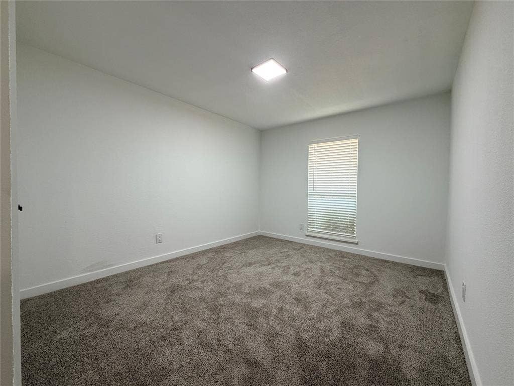 Neutral wall finishes, contemporary ceiling light fixture, window with horizontal blinds, and textured carpet flooring