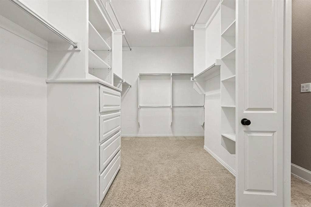 408 Blue Ridge Court, Allen, TX 75013 Walk-in closet featuring white built-in shelving, hanging rods, and a four-drawer dresser