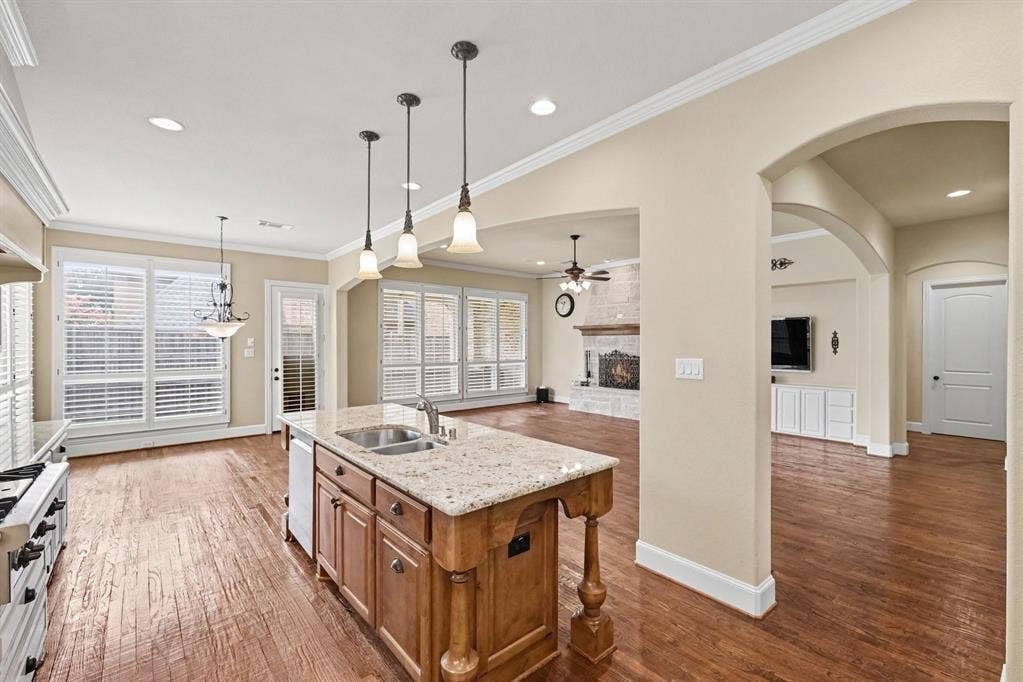 408 Blue Ridge Court, Allen, TX 75013 Kitchen island featuring granite-style countertops, dual basin sink, and pendant lighting