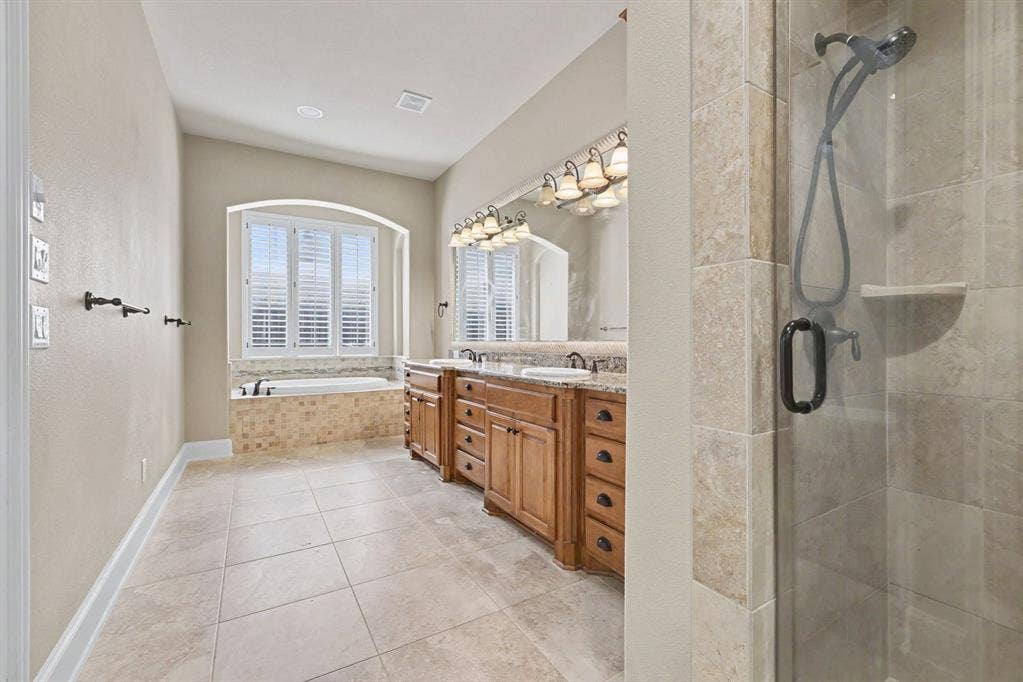 408 Blue Ridge Court, Allen, TX 75013 Tile flooring featuring an inset bathtub with a tiled surround