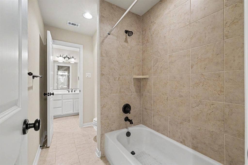 408 Blue Ridge Court, Allen, TX 75013 Bathtub with matte black fixtures, full-height wall tiling, and a built-in shelf- jack and jill bathroom