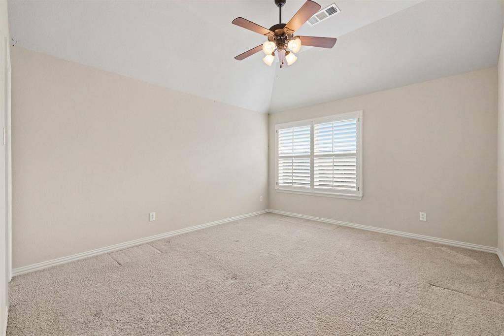 408 Blue Ridge Court, Allen, TX 75013 Vaulted ceiling with a ceiling fan light fixture, window with plantation shutters, and light-toned carpet flooring