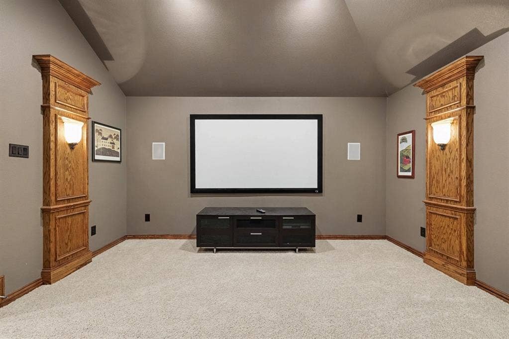 408 Blue Ridge Court, Allen, TX 75013 Dedicated media room featuring a large projection screen, recessed ceiling lighting, and built-in wall sconces with wood-finish paneling