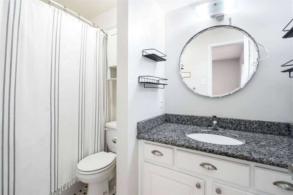 2711 Alco Avenue, Dallas, TX 75211 White vanity with a granite countertop, integrated sink, and an overhead light fixture