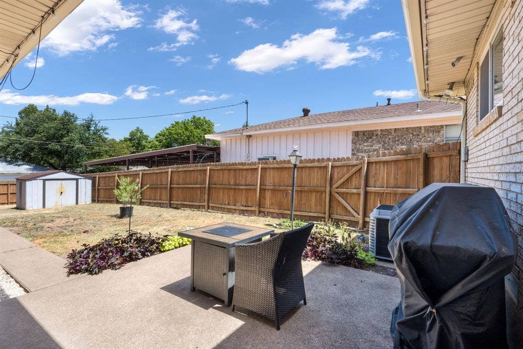 2711 Alco Avenue, Dallas, TX 75211 Concrete patio with an overhead awning, brick exterior, and a wooden privacy fence