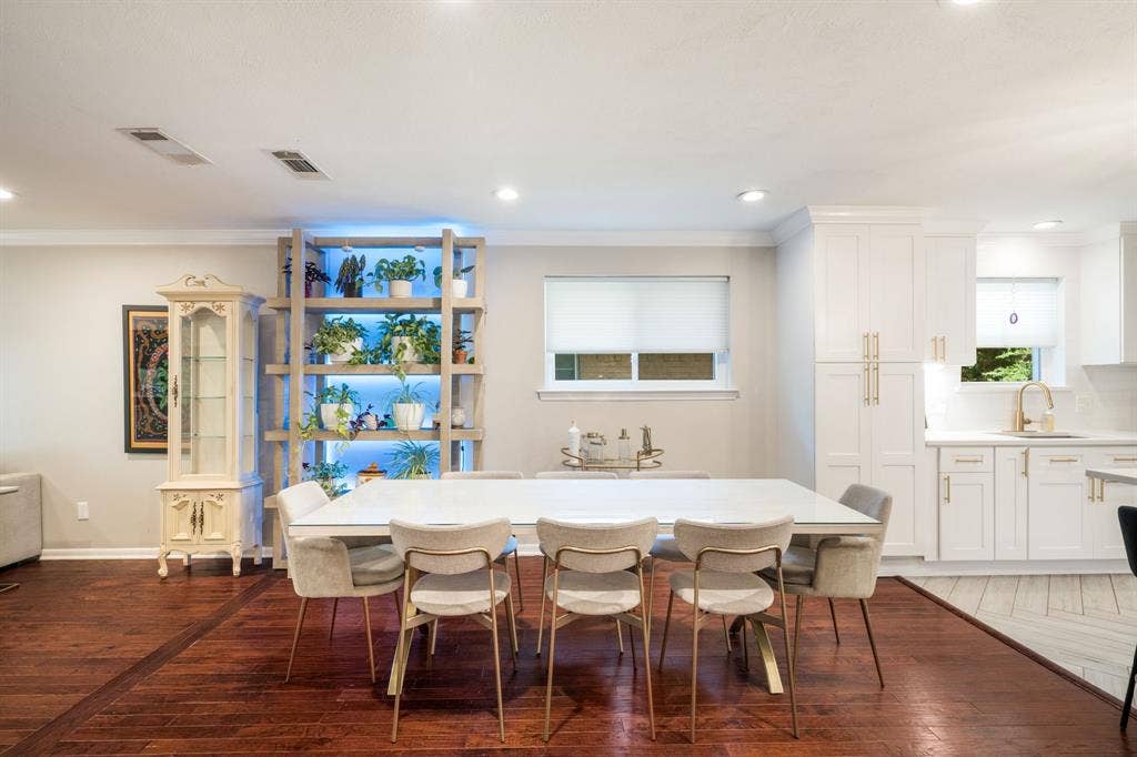 2711 Alco Avenue, Dallas, TX 75211 Hardwood flooring, recessed lighting, built-in shelving with integrated lighting, white shaker-style cabinetry, and subway tile backsplash