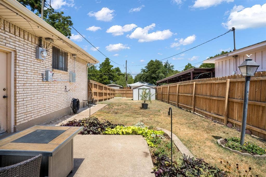 2711 Alco Avenue, Dallas, TX 75211 Expansive yard featuring a concrete patio, established landscaping, and wood privacy fencing