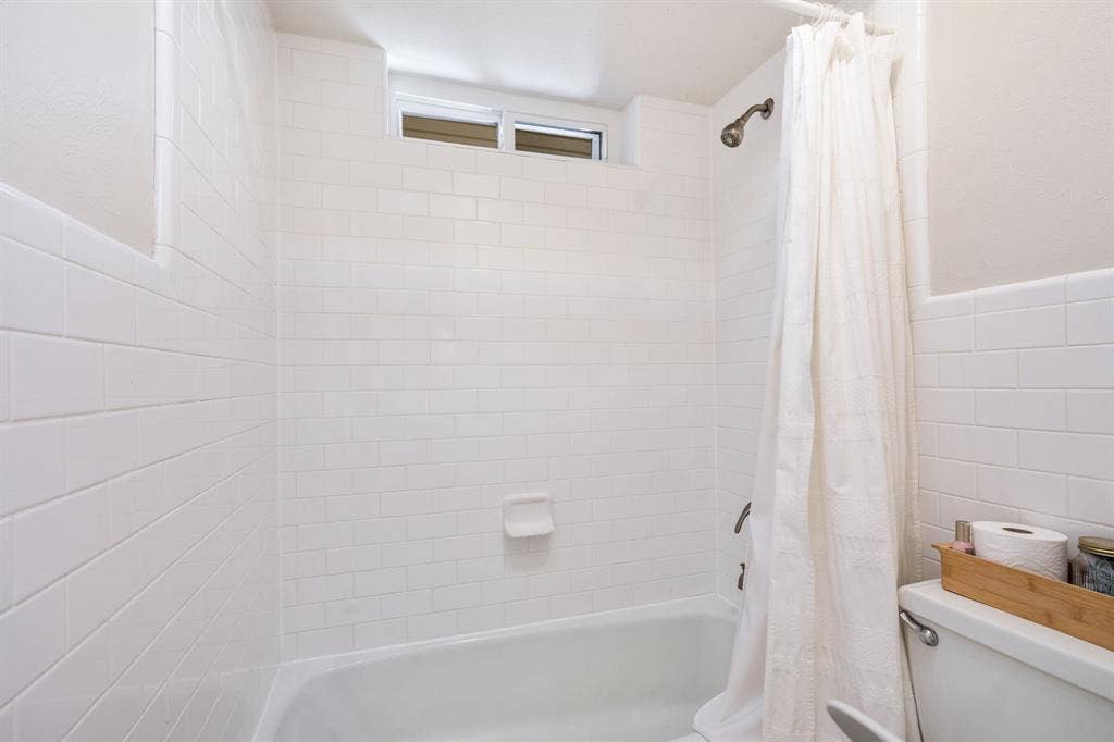 2711 Alco Avenue, Dallas, TX 75211 White subway tile surround, built-in bathtub, and an integrated shower head