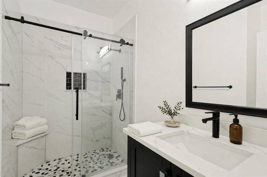 9604 Bull Creek Drive, Plano, TX 75025 Modern bathroom featuring a vanity with an integrated sink, black-framed mirror, and matte black fixtures