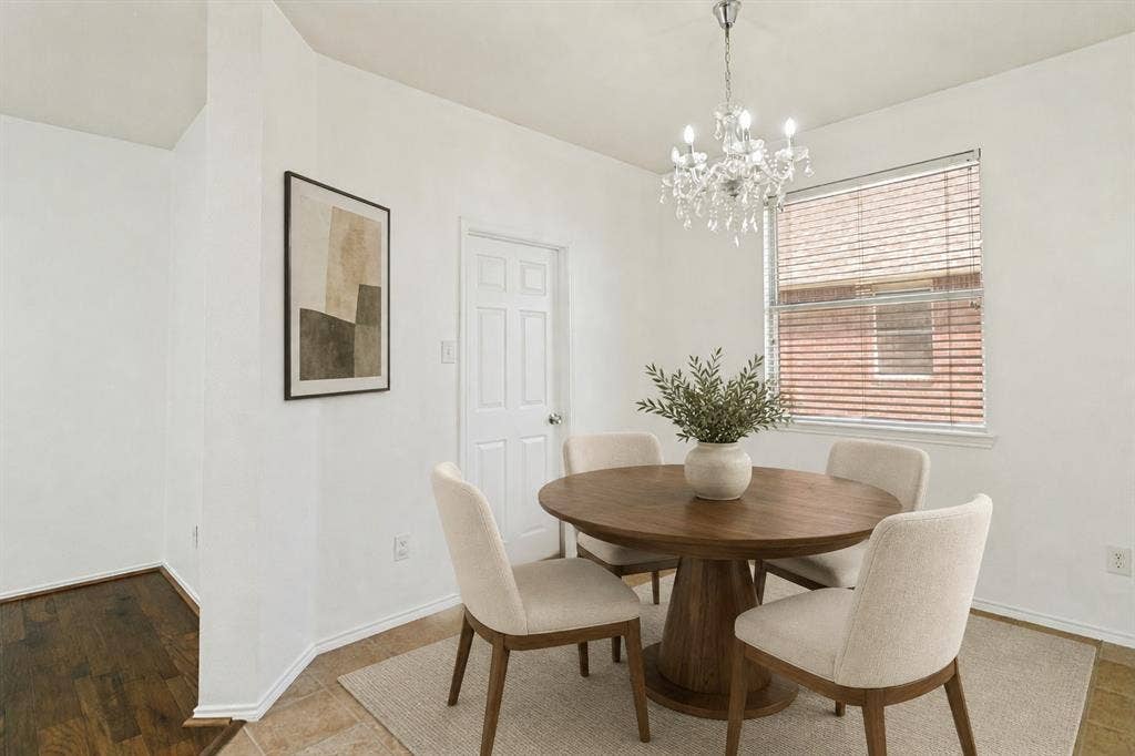 9604 Bull Creek Drive, Plano, TX 75025 Recessed dining area with a multi-pane window, crystal chandelier, and light-toned tile flooring