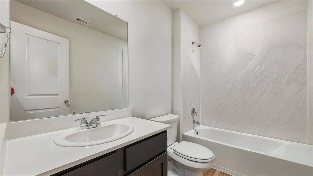 1912 Freeman Street, Tyler, TX 75702 White rectangular vanity with undermount sink, dual-handle chrome faucet, and dark wood-finish cabinetry