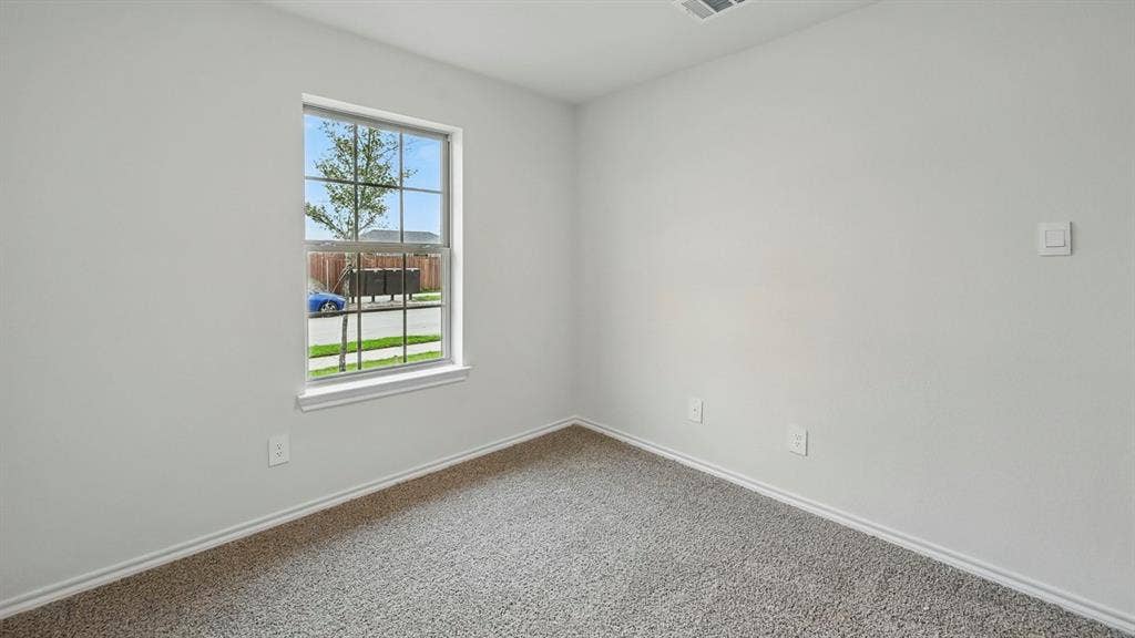 1912 Freeman Street, Tyler, TX 75702 Neutral wall paint, window with grid panes, textured carpeting, and white trim