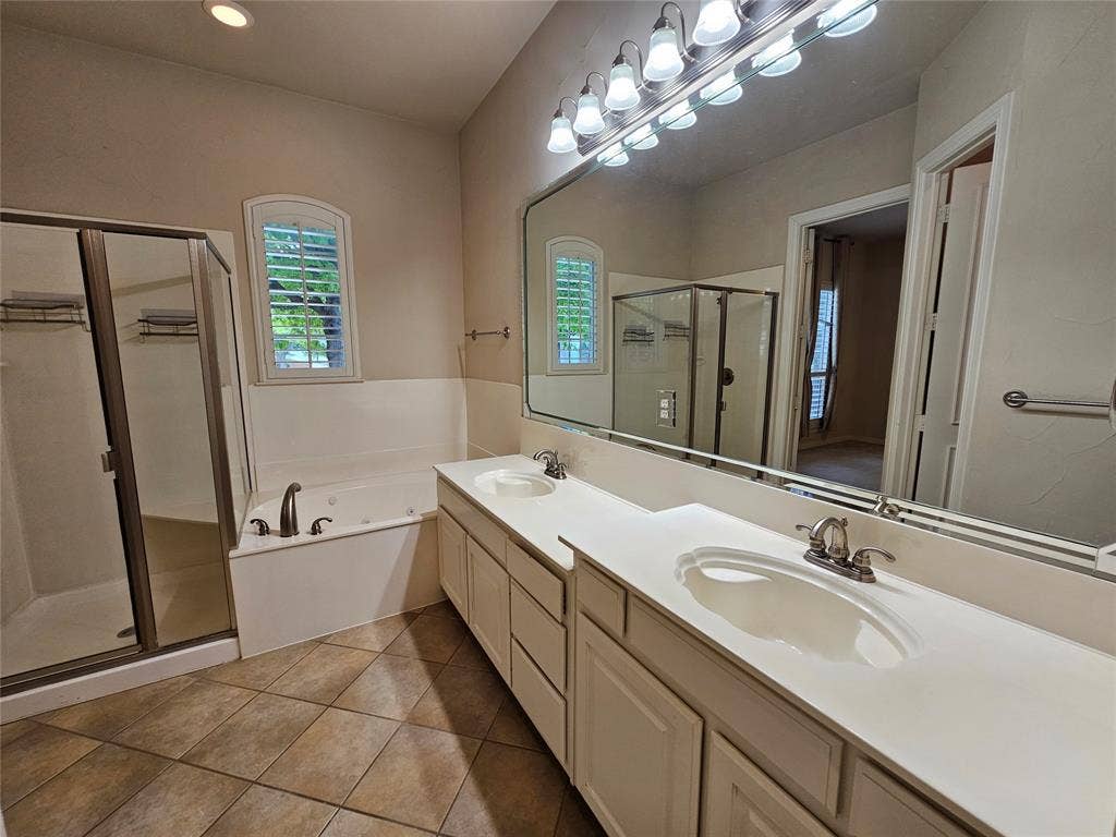 1009 Ricci Court, Irving, TX 75062 Dual vanity with integrated sinks, full-width mirror, and a multi-bulb lighting fixture