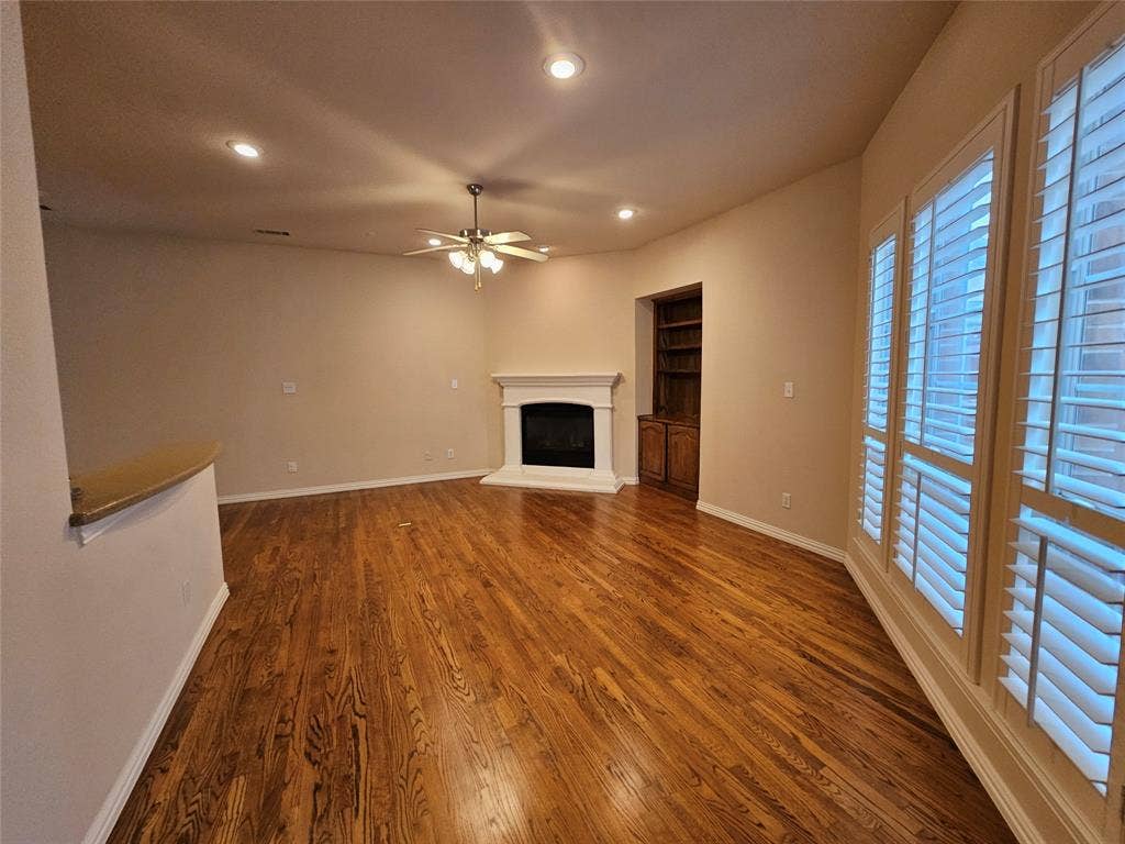 1009 Ricci Court, Irving, TX 75062 Hardwood flooring, recessed lighting, ceiling fan with light fixture, fireplace with mantel, and built-in cabinetry