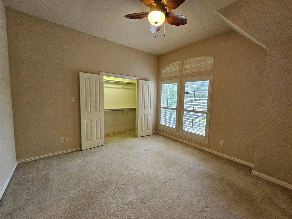 1009 Ricci Court, Irving, TX 75062 Vaulted ceiling with a ceiling fan, carpeted flooring, and a double-door closet