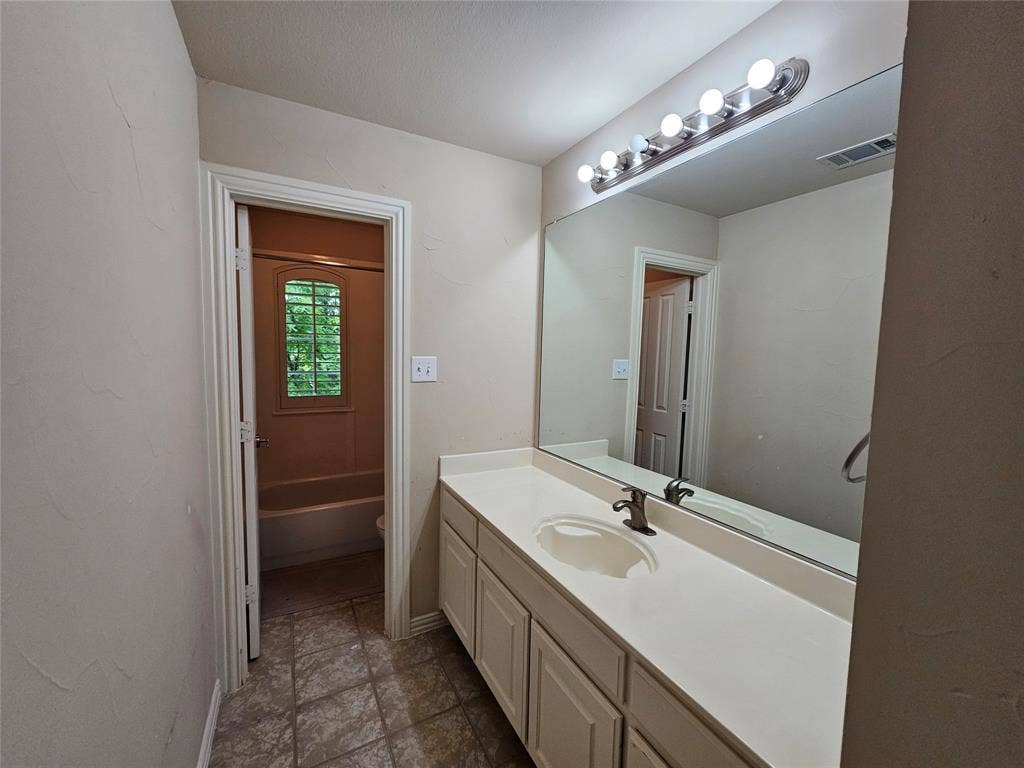 1009 Ricci Court, Irving, TX 75062 Expansive vanity with a single integrated sink, light-toned countertop, and white cabinetry