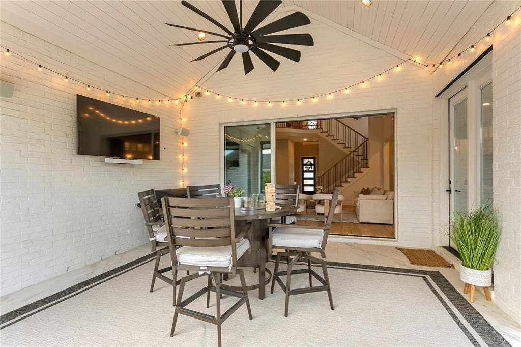 1581 Turnberry Drive, Prosper, TX 75078 String-lit covered patio with a mounted TV and ceiling fan extends the living space outdoors.