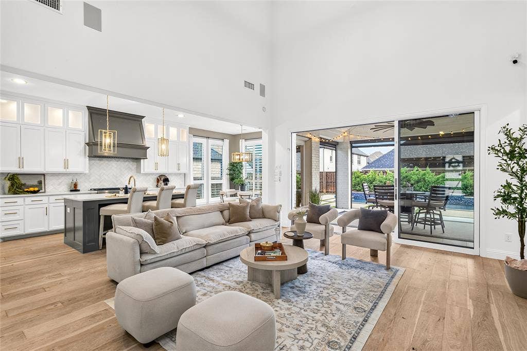 1581 Turnberry Drive, Prosper, TX 75078 Soaring ceilings and a full wall of sliding glass doors flood the great room with natural light.