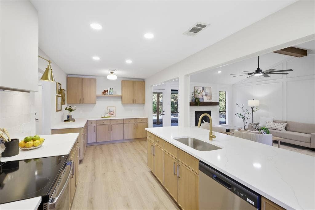 Contemporary kitchen with wood-finish cabinetry, white countertops, stainless steel appliances, and wood-finish flooring