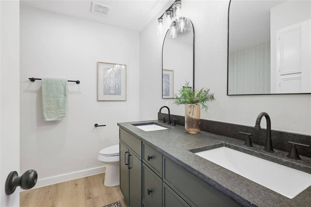 Dual vanity with dark cabinetry and integrated sinks, complemented by matte black fixtures