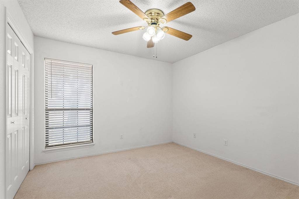 Neutral wall finishes, carpeted flooring, window with blinds, and ceiling fan with integrated lighting