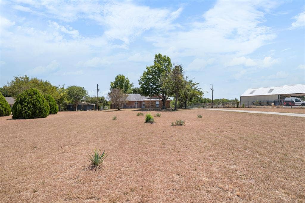 Expansive lot featuring a single-story residence and a large metal outbuilding