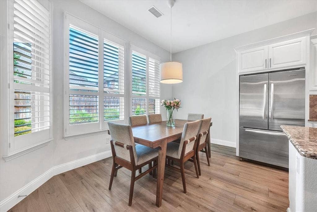 Wood-finish flooring with white baseboards and an integrated appliance
