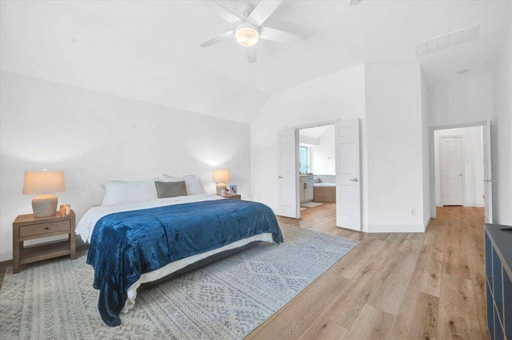 Vaulted ceiling with a ceiling fan, recessed lighting, wood-finish flooring, and white paneled doors