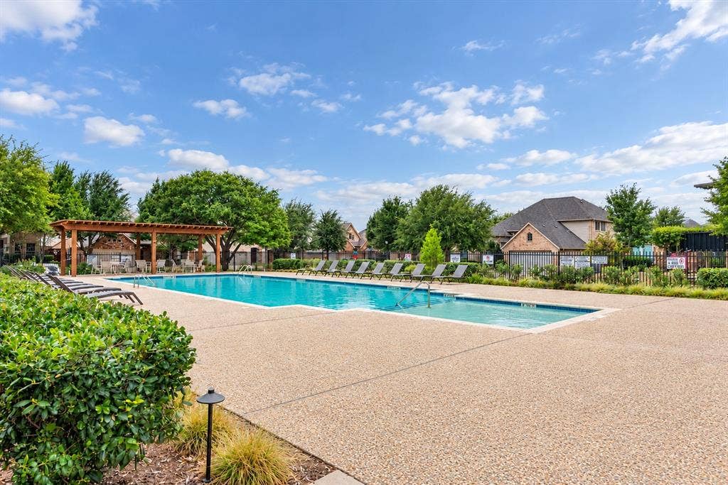 Large outdoor swimming pool with surrounding aggregate concrete decking