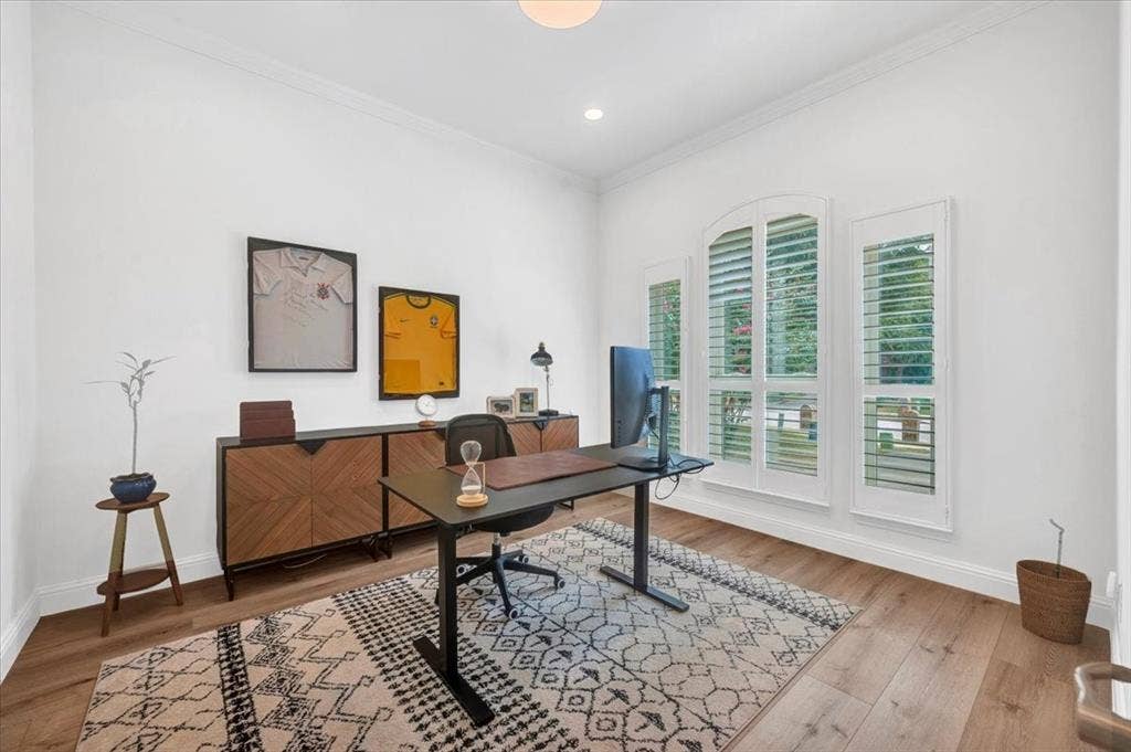 Wood-finish flooring, white walls, and crown molding
