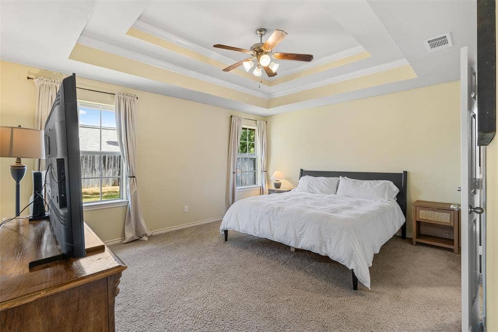 11848 County Road 167, Tyler, TX 75703 Tray ceiling with crown molding, ceiling fan, two windows, wall-to-wall carpeting, and light-colored walls