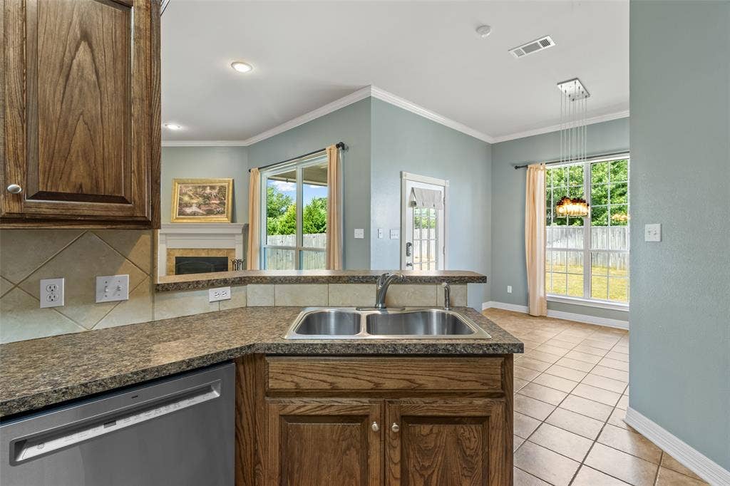 11848 County Road 167, Tyler, TX 75703 Kitchen featuring wood-finish cabinetry, a double basin stainless steel sink, and speckled countertops