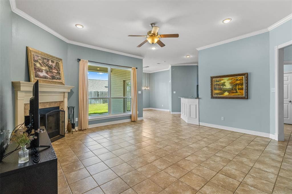 11848 County Road 167, Tyler, TX 75703 Spacious living area featuring tile flooring, a fireplace with a mantel, a ceiling fan, recessed lighting, and a large window overlooking the backyard