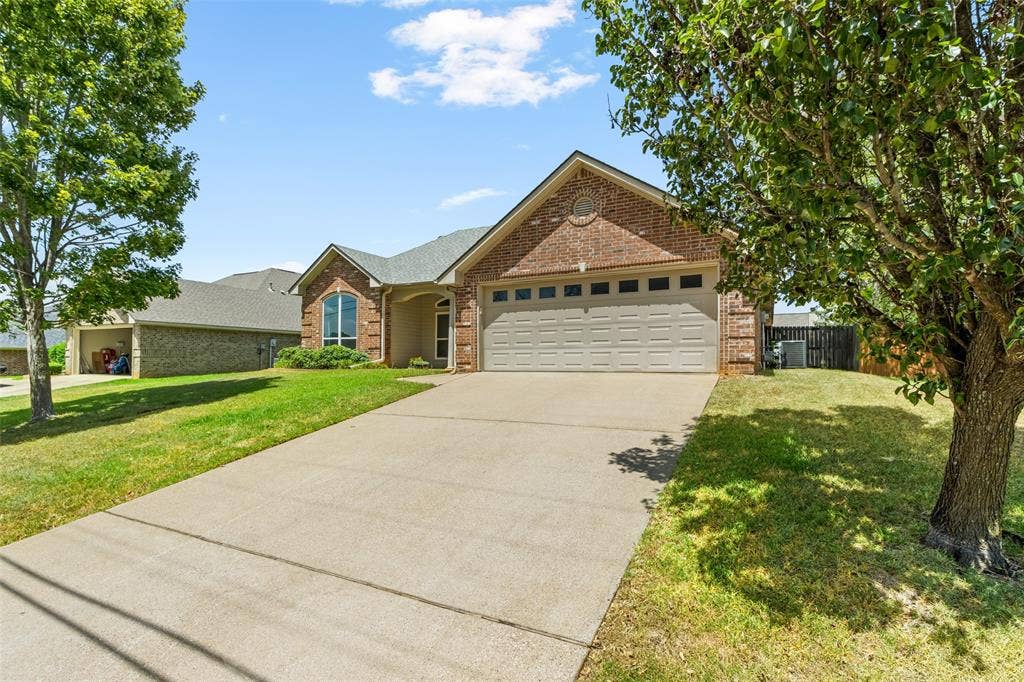 11848 County Road 167, Tyler, TX 75703 Brick exterior with a two-car garage, concrete driveway, and mature landscaping