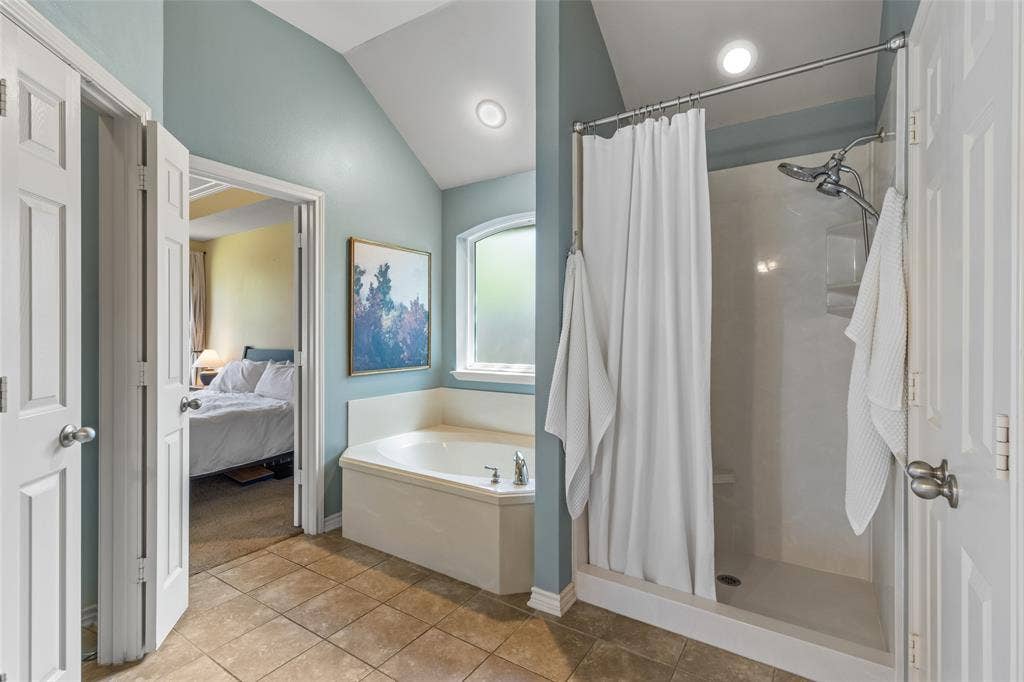 11848 County Road 167, Tyler, TX 75703 Corner soaking tub, separate shower with tiled surround, vaulted ceiling, recessed lighting, and tile flooring