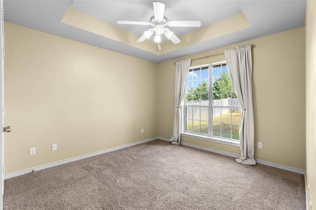11848 County Road 167, Tyler, TX 75703 Tray ceiling with a ceiling fan, carpet flooring, and a large window