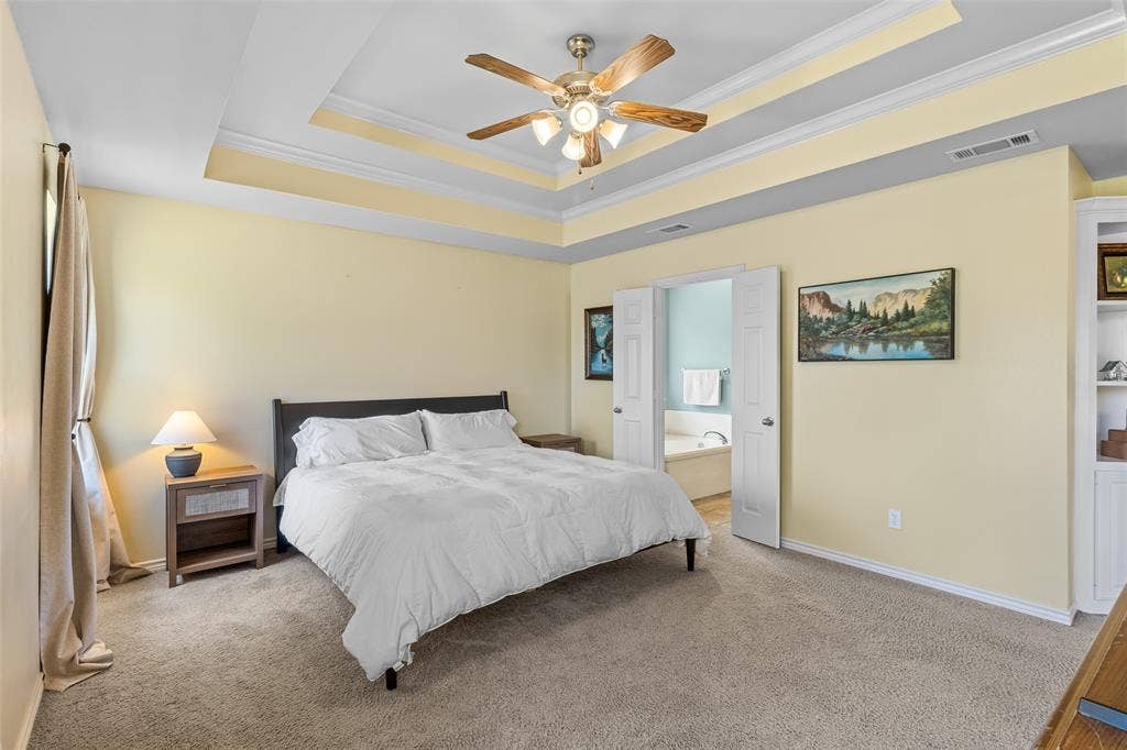 11848 County Road 167, Tyler, TX 75703 Tray ceiling with crown molding, carpeted flooring, built-in shelving, and a ceiling fan with integrated lighting