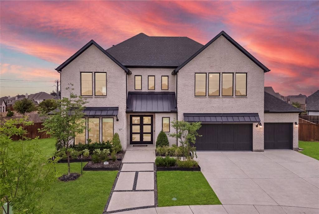 467 Mayfair Lane, Frisco, TX 75033 Contemporary brick facade with dark trim accents, featuring a multi-pane front door, a concrete driveway, and a manicured lawn