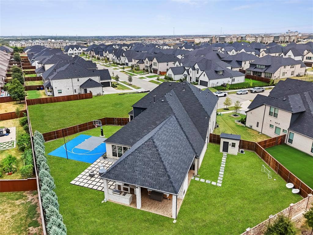 467 Mayfair Lane, Frisco, TX 75033 Expansive backyard featuring a manicured lawn, covered patio, sport court, and detached storage shed