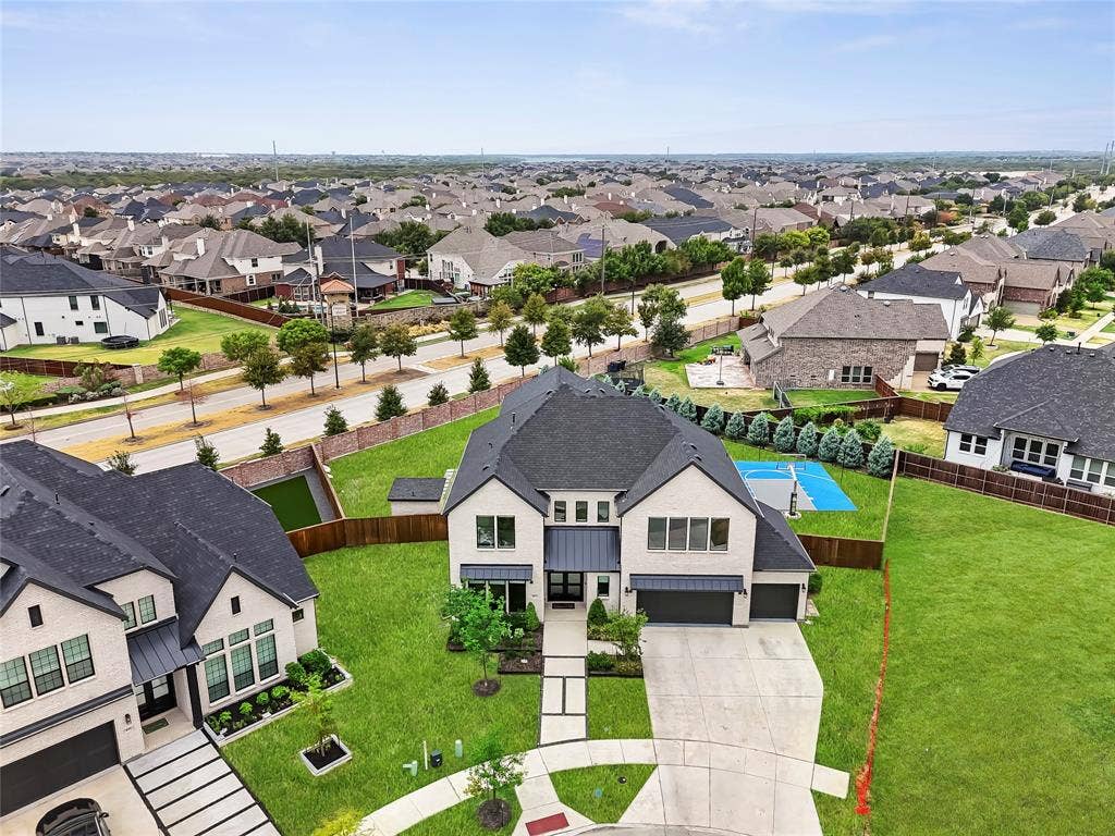 467 Mayfair Lane, Frisco, TX 75033 Two-story residence with a dark shingle roof, light-colored brick exterior, and an attached two-car garage
