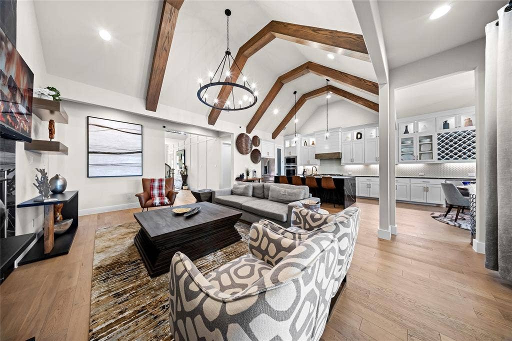 467 Mayfair Lane, Frisco, TX 75033 Vaulted ceiling with exposed wood beams, central chandelier, and wood-finish flooring