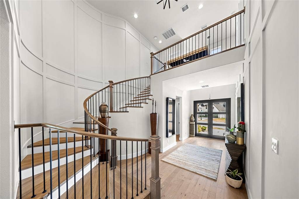467 Mayfair Lane, Frisco, TX 75033 Grand foyer featuring a spiral staircase with wood treads, black metal balusters, and a wood handrail