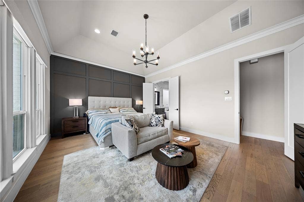 467 Mayfair Lane, Frisco, TX 75033 Vaulted ceiling featuring a contemporary chandelier, wood-finish flooring, and a paneled accent wall