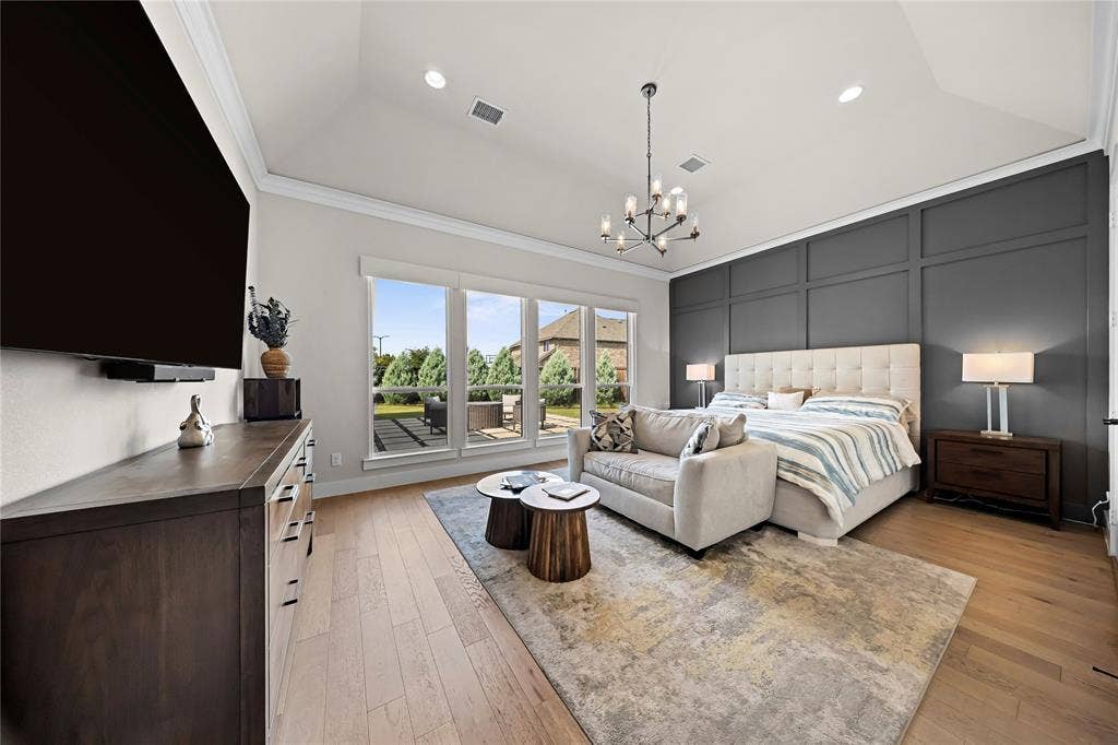 467 Mayfair Lane, Frisco, TX 75033 Vaulted ceiling with recessed lighting, wood-finish flooring, a wall of windows, dark paneled accent wall, and a contemporary chandelier