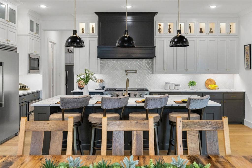 1561 Saint Peter, Prosper, TX 75078 Gourmet kitchen featuring a large central island, a custom range hood, stainless steel appliances, and abundant cabinetry with glass-front accents