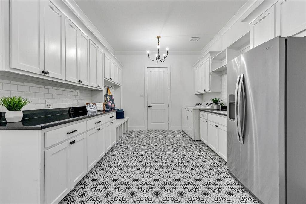1561 Saint Peter, Prosper, TX 75078 White cabinetry, black countertops, patterned floor tiling, subway tile backsplash, and a black chandelier