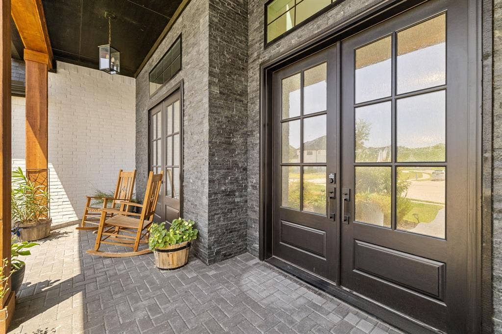 1561 Saint Peter, Prosper, TX 75078 Double-door entry with divided lites, framed by stacked stone veneer and painted brick