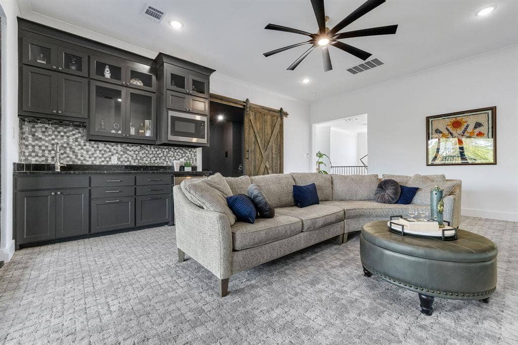 1561 Saint Peter, Prosper, TX 75078 Built-in wet bar with dark cabinetry, mosaic tile backsplash, and stainless steel microwave
