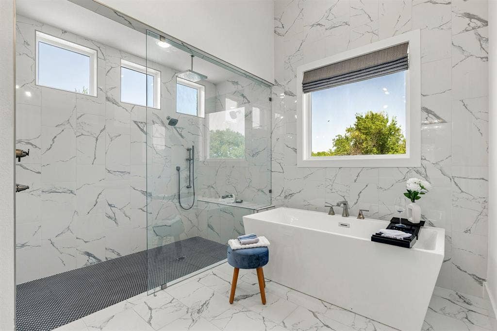 1561 Saint Peter, Prosper, TX 75078 Freestanding soaking tub with polished chrome fixtures, walk-in shower with glass enclosure, rain shower head, and bench seating