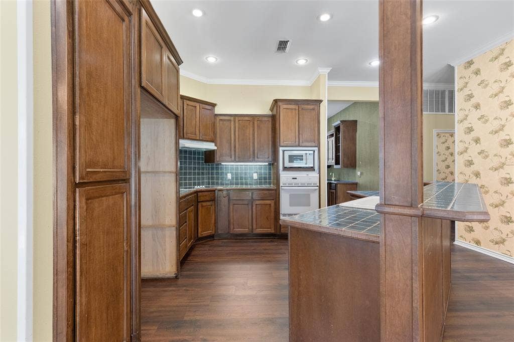 1200 County Road 2307, Sulphur Springs, TX 75482 Spacious kitchen with island and breakfast bar, pantry cabinet, plus a large pantry closet, wet bar area, and warming oven near the pantry.